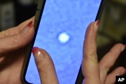 琳赛·麦克唐纳 (Lindsay McDonald) 用手机在蒙大拿州中部拍摄的一张气球照片。这个据信是中国间谍气球的球体在拥有数十个核导弹发射井的区域上空飞行。(2023 年2月7日。)