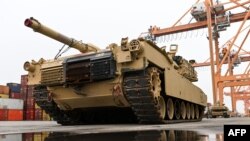 FILE - A U.S. M1A2 Abrams battle tank intended for use during military exercises by the 2nd Armored Brigade Combat Team, is unloaded at the Baltic Container Terminal in Gdynia, Poland, Dec. 3, 2022.