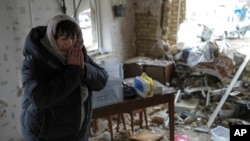 Halina Panasian, 69, reacts inside her destroyed house after a Russian rocket attack in Hlevakha, Kyiv region, Ukraine, Jan. 26, 2023.