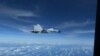 美國印太司令部通過路透社公佈的照片顯示：美國空軍RC-135飛機在南中國海國際空域拍下中國海軍殲-11戰機貼近飛行的情景。 (2022年12月21日)