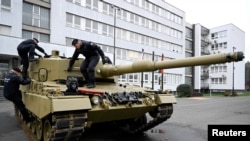 Pripadnici vojske hodaju po tenku, dok Njemačka isporučuje svoje prve tenkove Leopard Slovačkoj kao dio dogovora nakon što je Slovačka donirala borbena vozila Ukrajini, u Bratislavi, Slovačka, 19. decembra 2022. REUTERS/Radovan Stoklasa