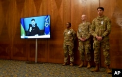 U.S. soldiers attend the opening speech of Ukrainian President Volodymyr Zelenskyy, via video screen, during the meeting of the Ukraine Security Contact Group at Ramstein Air Base in Ramstein, Germany, Jan. 20, 2023.