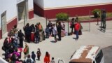 Migrantes de México y Centroamérica que buscan asilo caminan cerca del cruce fronterizo del Puerto de Entrada de San Ysidro con EEUU, en Tijuana, México, el 5 de mayo de 2022.