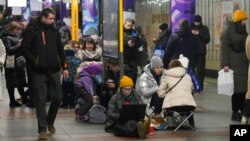 People gather in a subway station being used as a bomb shelter during a rocket attack in Kyiv, Ukraine, Jan. 26, 2023.