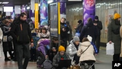 People gather in a subway station being used as a bomb shelter during a rocket attack in Kyiv, Ukraine, Jan. 26, 2023.