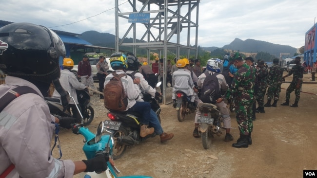 Personel TNI-POLRI melakukan pemeriksaan terhadap pekerja yang hendak memasuki pabrik smelter PT GNI di Morowali Utara, Sulawesi Tengah, 19 Januari 2023 menyusul terjadinya bentrok antara pekerja Indonesia dan China. (Foto : VOA/Yoanes Litha)