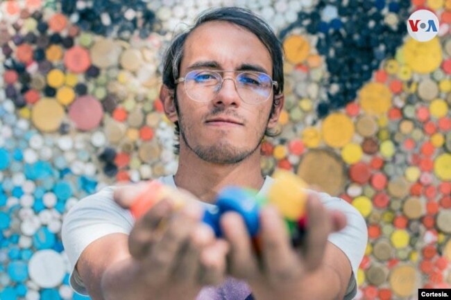 Seniman Venezuela, Oscar Olivares, menunjukkan beberapa elemen (tutup botol plastik) yang ia gunakan untuk membuat mural. (dok: VOA)