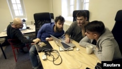 ARCHIVO - Los periodistas trabajan en la oficina de Meduza, una empresa de medios independiente y enfocada en Rusia, en Riga en marzo de 2015.