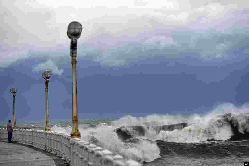 A person looks at waves during a high tide in San Sebastian, northern Spain. (AP Photo/Alvaro Barrientos)