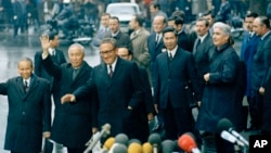 總統國家安全事務顧問亨利-基辛格博士（左三）與北越的黎德壽在巴黎國際會議中心舉行的最後一次會議後揮手示意。（美聯社照片，1973年1月23日）