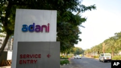 Vehicles move past a signage near the entrance of Adani Corporate House in Ahmedabad, India, Jan. 27, 2023.