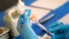 FILE - A nurse prepares a syringe of a COVID-19 vaccine at an inoculation station in Jackson, Mississippi, July 19, 2022.