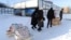 People carry their belongings at a modular town for refugees from war-hit Ukrainian regions in Lviv, Ukraine, Feb. 9, 2023.