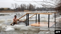 A Ukrainian serviceman bathes in the icy Siverskyi Donets River next to the Sviatohirsk Orthodox Christian Monastery in the town of Svyatohirsk, Donetsk region, Ukraine, Jan.19, 2023.