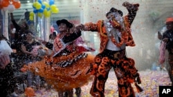 Una Chola y una Chuta, ambas concursantes, muestran su vibra de felicidad durante una competencia para elegir a los tres personajes principales del Carnaval - Chuta, Pepino y Chola - en La Paz, Bolivia, el viernes 10 de febrero de 2023.