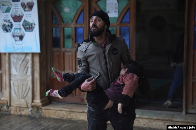 A Syrian man carries a dead young girl, in Azmarin town, in Idlib province north Syria, Monday, Feb. 6, 2023. (AP Photo/Ghaith Alsayed)