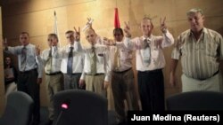 Los ex-presos cubanos Lester González, Antonio Villarreal, Pablo Pacheco, José Luis García Paneque, Julio César Gálvez, Ruiz, Omar y Ricardo González (de izquierda a derecha) posan para los fotógrafos a su llegada al aeropuerto de de Barajas, Madrid, el 13 de julio de 2010.