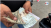 Un ciudadanos muestra billetes de dólares estadounidenses y bolívares en Venezuela, una nación cuyo salario mínimo mensual es menor a los $6.