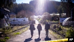 Oficiales del FBI caminan hacia la escena del crimen en Mountain Mushroom Farm, el martes 24 de enero de 2023, luego de que un hombre armado matara a varias personas en dos negocios agrícolas en Half Moon Bay, California.