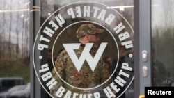 Seorang pria mengenakan seragam kamuflase berjalan keluar dari PMC Wagner Center, saat pembukaan resmi blok kantor di Saint Petersburg, Rusia, 4 November 2022. (REUTERS/Igor Russak)