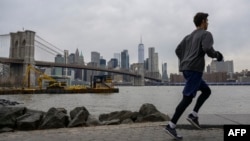 一名男子在河边跑步，对岸是纽约曼哈顿。（2023年1月25日）