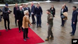 Ukrainian President Volodymyr Zelenskyy, center right, and European Commission President Ursula von der Leyen greet each other during the EU-Ukraine summit in Kyiv, Ukraine, Feb. 2, 2023, in this photo provided by the Ukrainian Presidential Press Office.