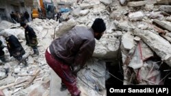 Syrian Civil Defense workers and security forces search through the wreckage of buildings, in Aleppo, Syria, Monday, February 6, 2023. (AP Photo/Omar Sanadiki)