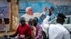 Petugas polisi lalu lintas berdiri di depan mural Paus Fransiskus di dinding gereja di Juba, Sudan Selatan, 2 Februari 2023. (Foto: AP)