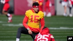 Patrick Mahomes (15), quarterback de los Chiefs de Kansas City, estira con sus compañeros, incluido el running back Clyde Edwards-Helaire (25), durante el entrenamiento del equipo en Tempe, Arizona, el miércoles 8 de febrero de 2023. Los Chiefs jugarán en contra de los Eagles de Filadelfia en el Super Bowl 57 el domingo. (AP Foto/Ross D. Franklin)