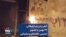 آتش زدن بنر تبلیغاتی ۲۲ بهمن با تصویر خمینی، خامنه‌ای و سلیمانی