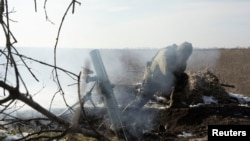 A Ukrainian serviceman fires a mortar shell towards Russian troops at the frontline position near the Vuhledar town, amid Russia's attack on Ukraine, in Donetsk region, Ukraine, Feb. 11, 2023.