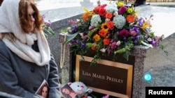 A mourner passes the burial site of Lisa Marie Presley, at Graceland Mansion in Memphis, Tennessee, Jan. 22, 2023.