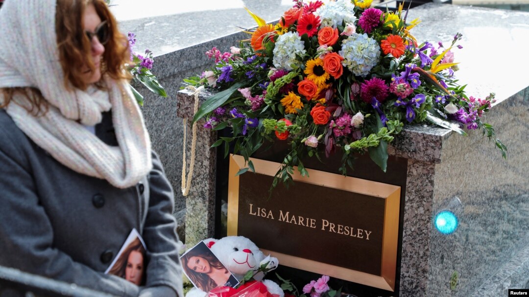 Seorang pelayat melewati lokasi pemakaman Lisa Marie Presley, di Graceland, Memphis, Tennessee, Minggu 22 Januari 2023.