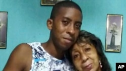 FILE- Pedro Yudel Bruzon, left, poses with his mother, Teresa Acosta, in Havana. Bruzon is looking for someone to vouch for him as a sponsor under a U.S. asylum program.