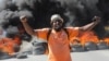 Un manifestante grita frente a una barricada en llamas durante protestas por recientes asesinatos de agentes de policía por pandillas armadas en Puerto Príncipe, Haití, el 26 de enero de 2023.
