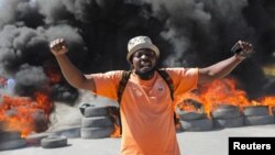 Un manifestante grita frente a una barricada en llamas durante protestas por recientes asesinatos de agentes de policía por pandillas armadas en Puerto Príncipe, Haití, el 26 de enero de 2023.
