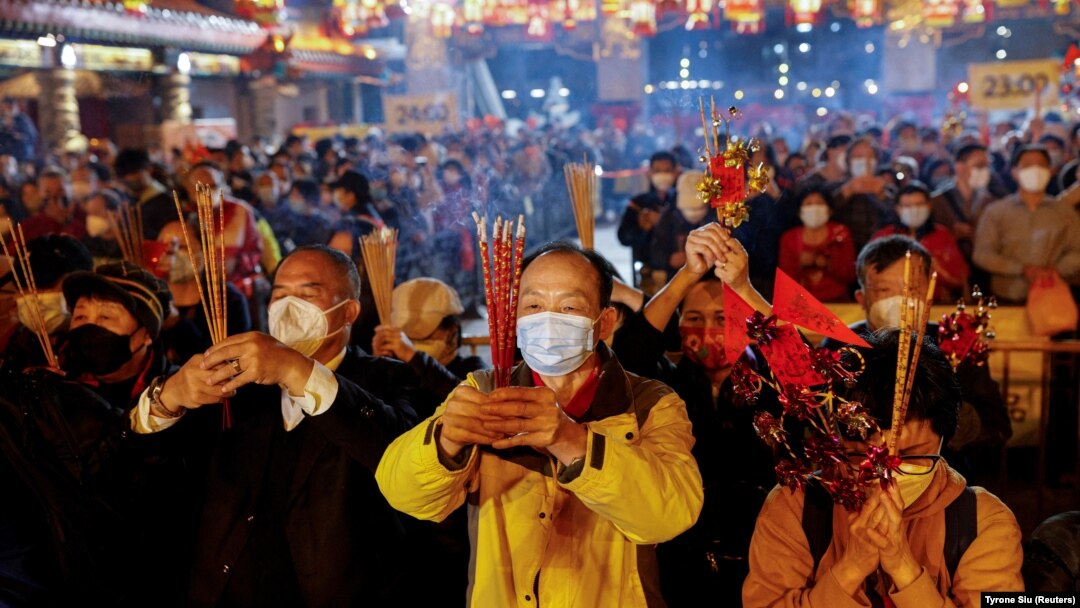 Para jemaah memberikan persembahan pertama mereka di dalam Kuil Wong Tai Sin, sesaat sebelum Tahun Baru Imlek, di tengah pandemi COVID-19 di Hong Kong, China, 21 Januari 2023. (Foto: REUTERS/Tyrone Siu)