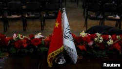 FILE - The flags of China and the Islamic Emirate of Afghanistan are displayed during a news conference held by officials of the two countries in Kabul, Jan. 5, 2023. Officials from China, Pakistan and the Afghan Taliban will hold talks starting May 5, 2023, in Islamabad.