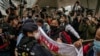 Photographers take picture of the members of League of Social Democrats scuffling with police outside the West Kowloon Magistrates' Courts ahead of the national security trail for the pro-democracy activists in Hong Kong, Feb. 6, 2023.