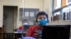 Chrystopher Camey Lopez uses a computer from a socially-distanced desk during an in-person hybrid learning day at the Mount Vernon Community School in Alexandria, Virginia, March 2, 2021.