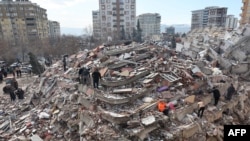 Warga sipil mencari korban selamat di bawah reruntuhan bangunan yang runtuh di Kahramanmaras, dekat pusat gempa, sehari setelah gempa bermagnitudo 7,8 melanda tenggara negara itu, pada 7 Februari 2023. (Foto: AFP)