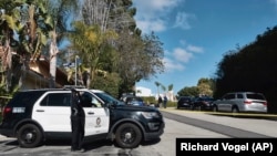 Polisi memblokir jalan menuju sebuah rumah tempat tewasnya tiga orang tewas di sebuah rumah di lingkungan kelas atas Los Angeles pada Sabtu 28 Januari 2023. (AP/Richard Vogel)