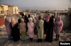 FILE - A group of Afghan women prosecutors stand on a rooftop overlooking Islamabad, as they wait for their asylum requests to be addressed after fleeing Afghanistan fearing persecution by the Taliban government, in Islamabad, Pakistan, Sept. 22, 2022.