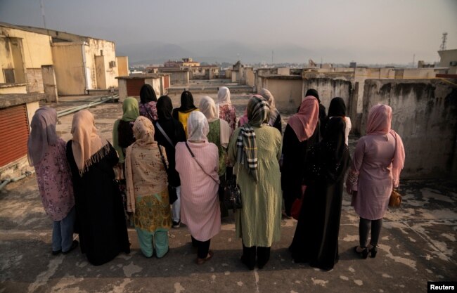 FILE - A group of Afghan women prosecutors stand on a rooftop overlooking Islamabad, as they wait for their asylum requests to be addressed after fleeing Afghanistan fearing persecution by the Taliban government, in Islamabad, Pakistan, Sept. 22, 2022.
