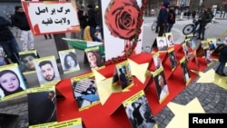 FILE - Pictures of people who died during anti-government demonstrations in Iran are displayed as Iranian community members and their supporters take part in a protest in solidarity with the Iranian people, in Paris, France, Feb. 12, 2023. 