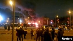 People look at a fire outside a hotel providing refuge to asylum seekers following a protest in Knowsley near Liverpool, Britain February 10, 2023 in this still image obtained from a social media video. 