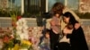 A family gathers at a memorial outside the Star Ballroom Dance Studio, Jan. 24, 2023, in Monterey Park, California.