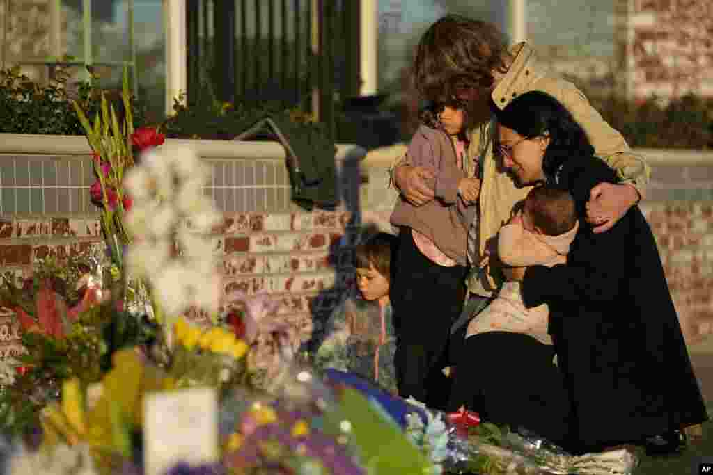 A family gathers at a memorial outside the Star Ballroom Dance Studio in Monterey Park, California, Jan. 24, 2023.&nbsp;A gunman killed multiple people at the ballroom dance studio late Saturday amid Lunar New Years celebrations in the mostly Asian-American community.