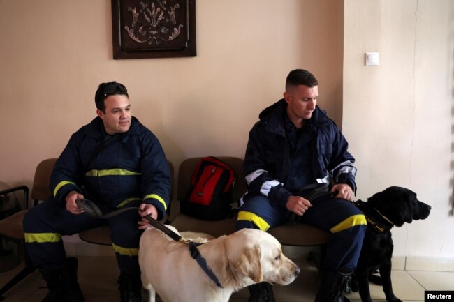 Members of the Disaster Response Special Unit with their dogs wait to board the Hellenic Air Force C-130, in order to fly to Turkey to help in the aftermath of an earthquake, before departing from the military airport of Elefsina, Greece, Feb. 6, 2023.
