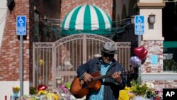 Gabriel Alexander toca una guitarra y canta cerca de un monumento fuera del Star Ballroom Dance Studio el martes, 24 de enero de 2023, en Monterey Park, California.